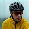 Fietser met regenjas onder een wolkenlucht